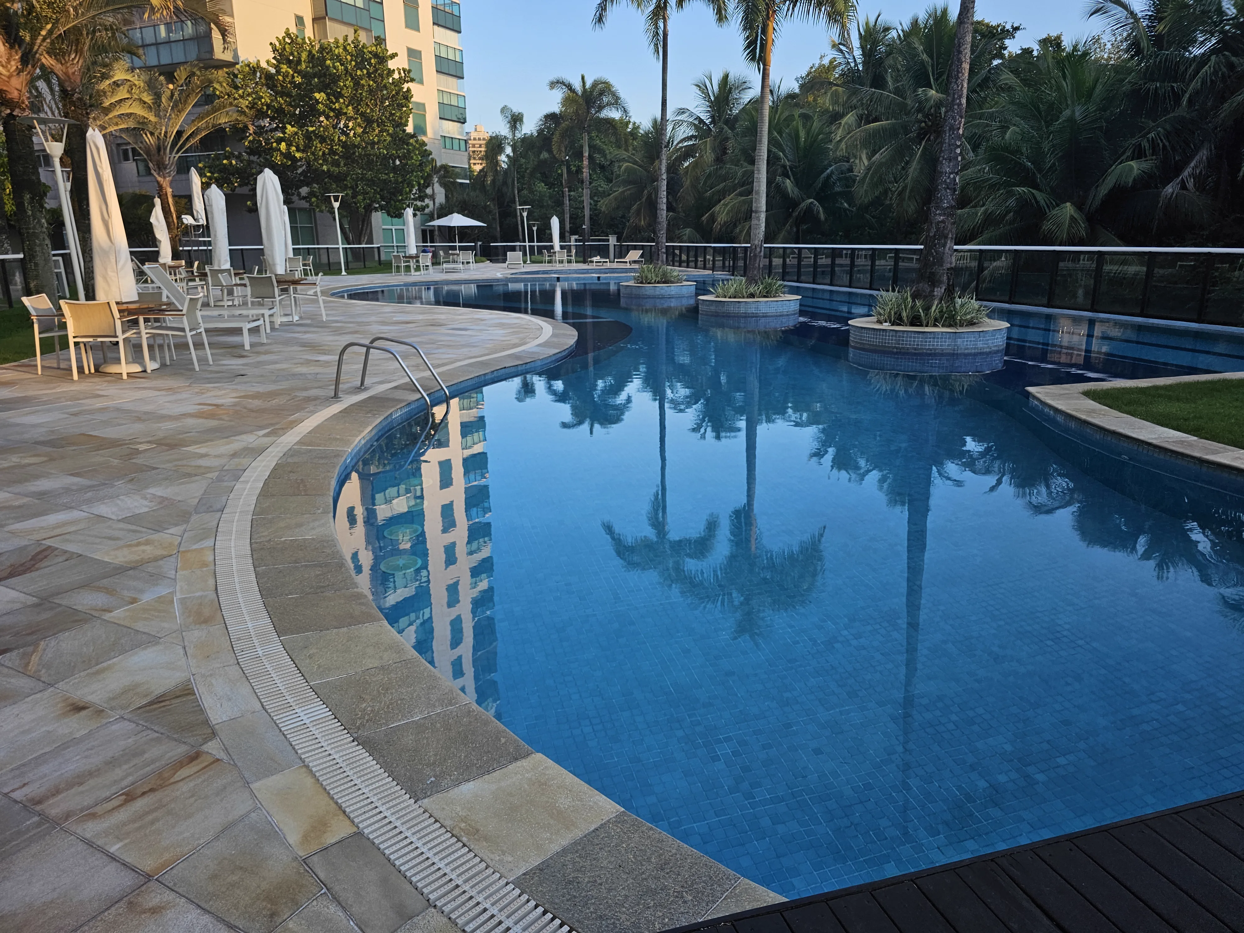 Piscina do condomínio com palmeiras tropicais