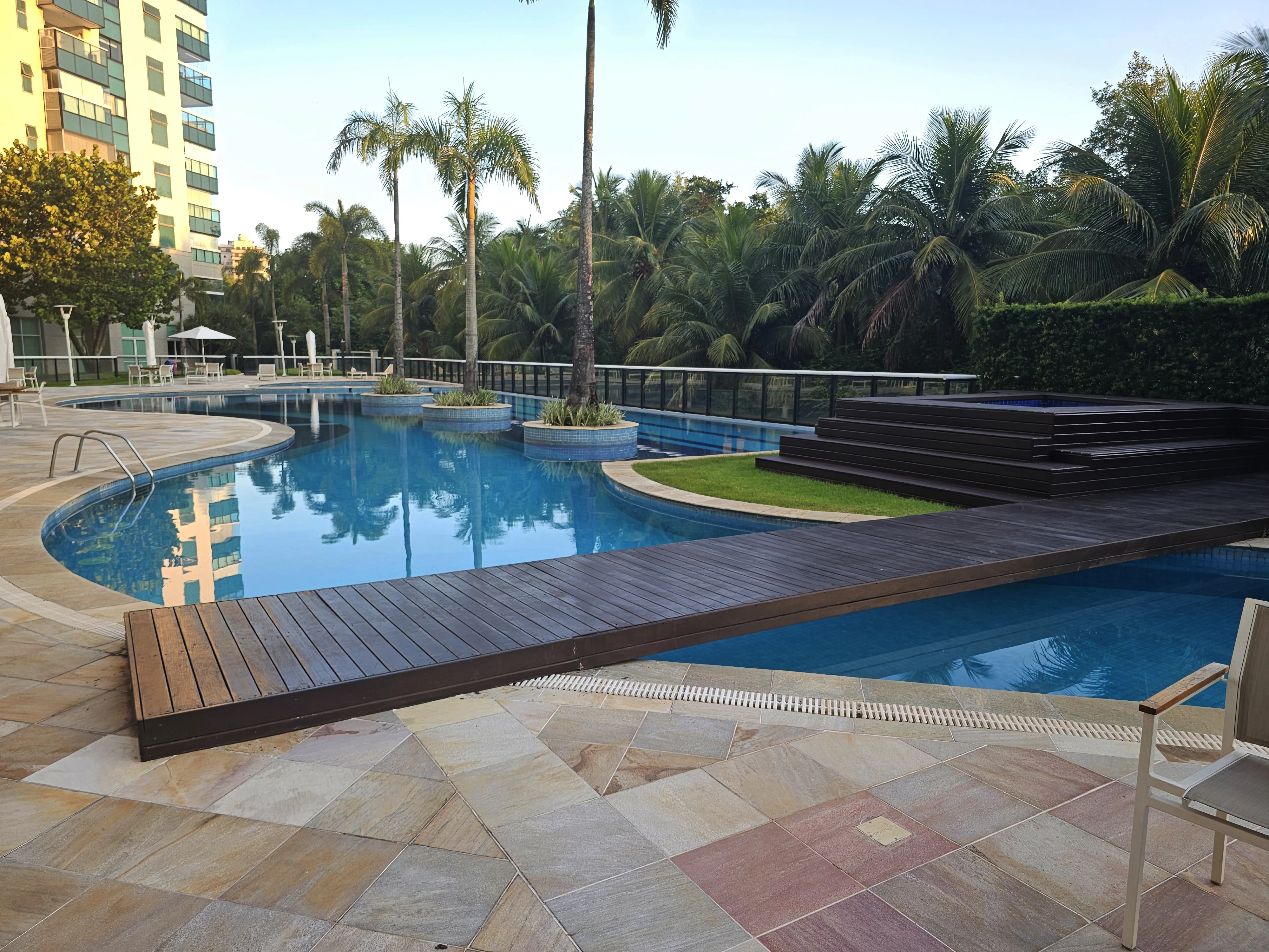 Piscina com deck de madeira e área lounge