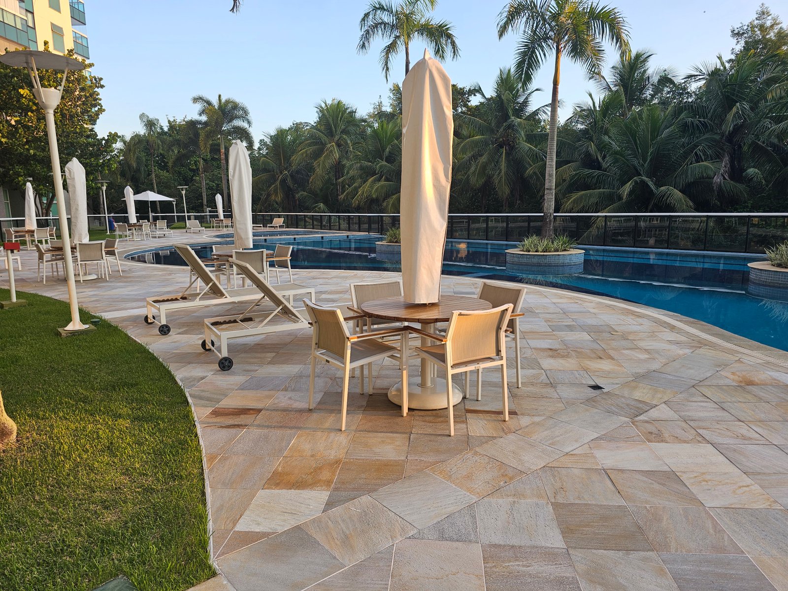 Área da piscina com espreguiçadeiras e guarda-sóis