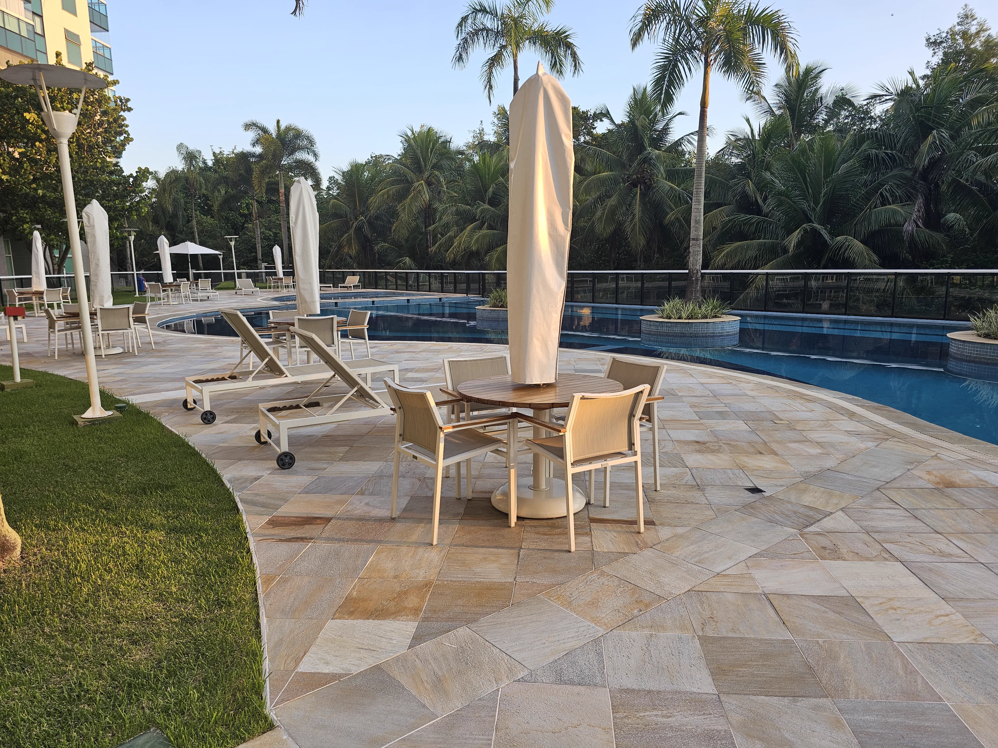 Área da piscina com espreguiçadeiras e guarda-sóis