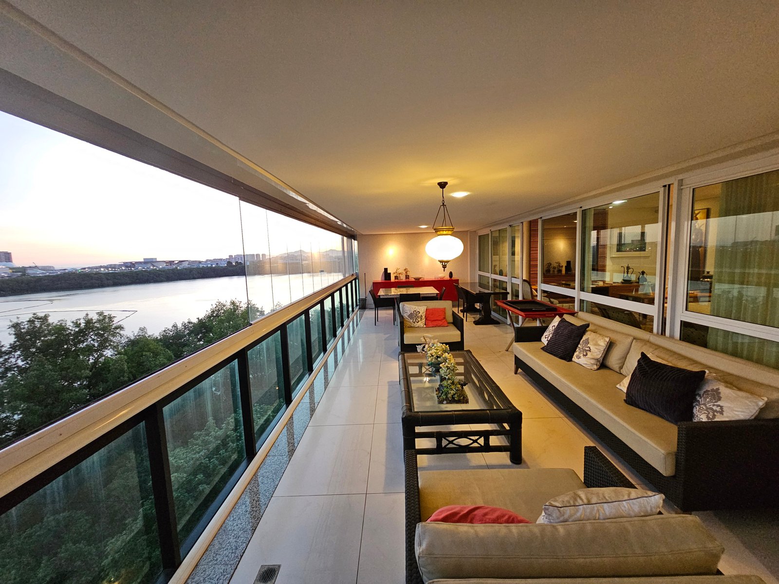 Varandão com sofás e vista para a Lagoa ao entardecer