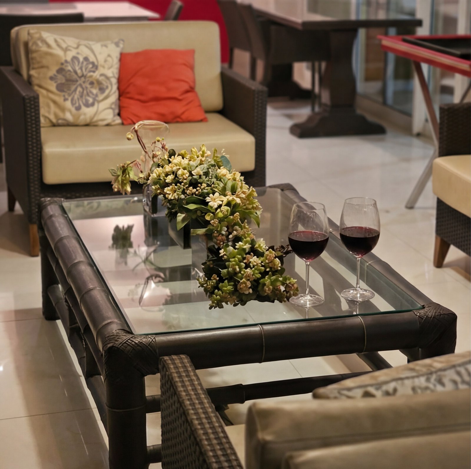 Mesa de centro com flores e taças de vinho tinto
