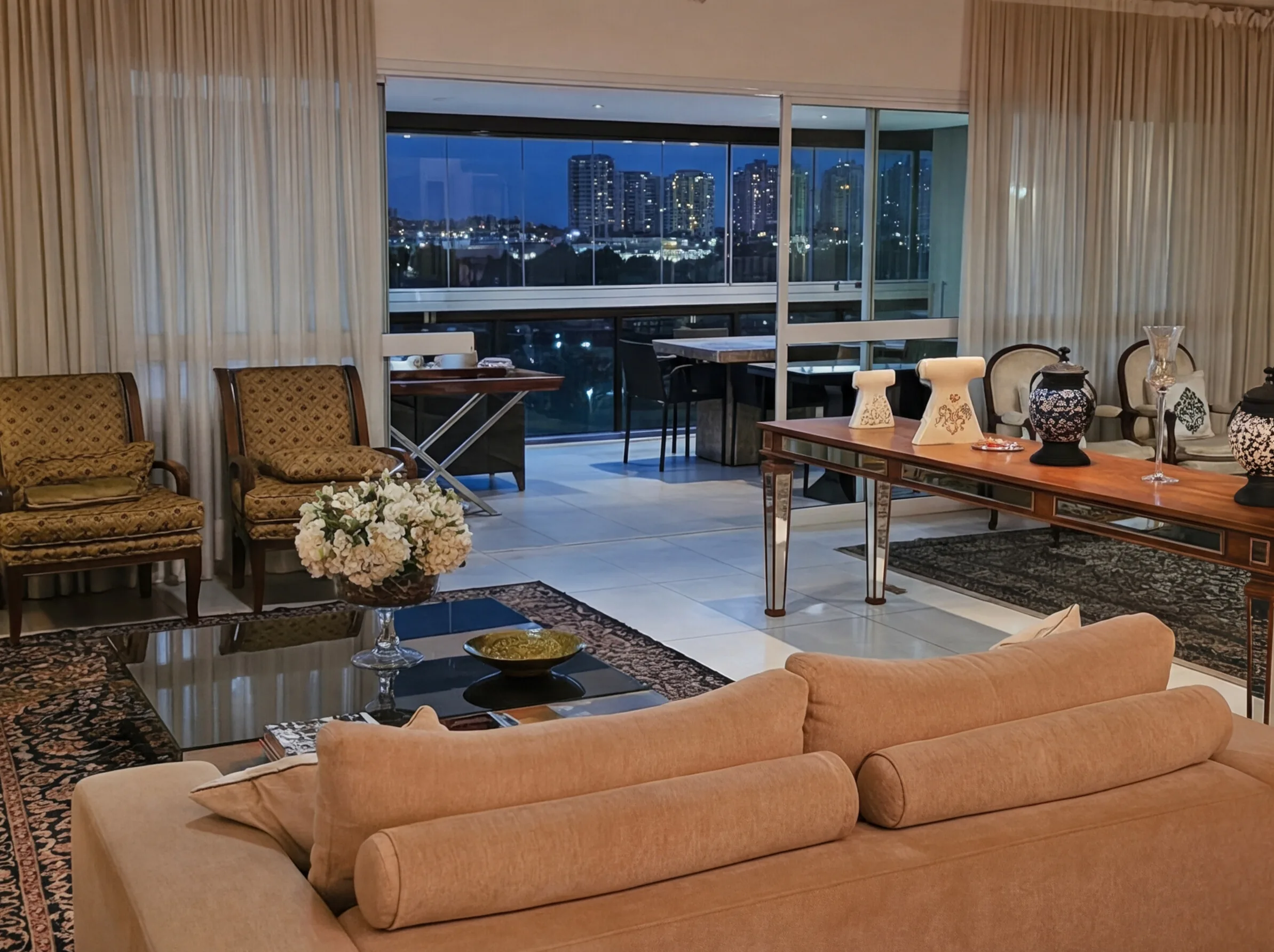 Sala de estar ampla com tapete persa e vista noturna para a Península