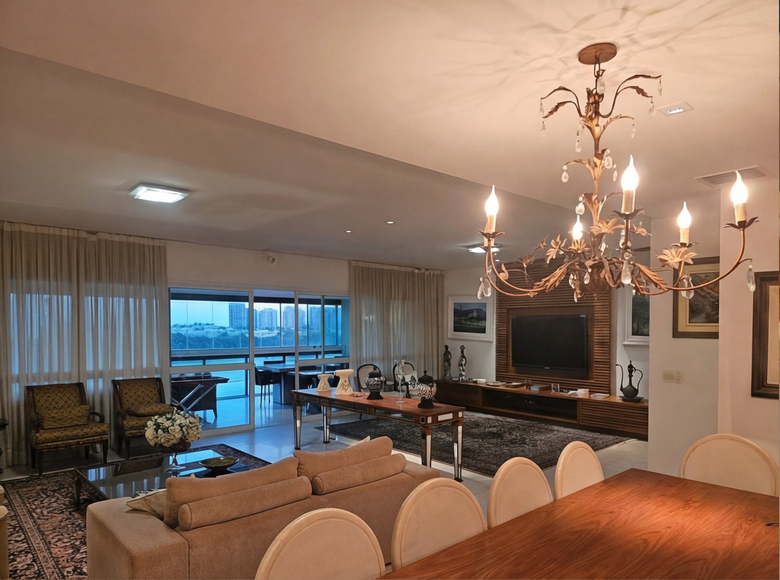 Sala de jantar com lustre dourado e mesa posta para receber